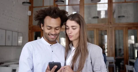 Young mixed race couple of students or coworking discussing new application Stock Footage 82680203