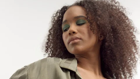 Young mixed race model in studio on white with curly hair, bright green eye Stock Footage 111319215