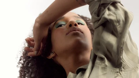 Young mixed race model in studio on white with curly hair, bright green eye Stock Footage 111319463