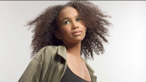 Young mixed race model in studio on white with curly hair, bright green eye Stock Footage 111321117