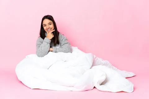 Young mixed race woman wearing pijama sitting on the floor happy and smiling Stock Photos