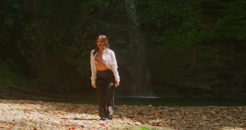A young model in a bikini at an amazing waterfall Stock Footage 330961508