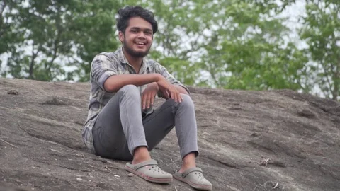 Young model enjoying in the wild forest on rock indian youth Video stock 108896181