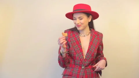 Young model in jacket and hat eats cookies and smiles Stock Footage 73371929