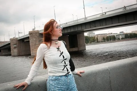 A young model in light-colored jeans walks around the city. Mild spring weather. Stock Photos