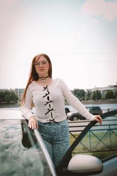 A young model in light-colored jeans walks around the city. Mild spring weather. Stock Photos