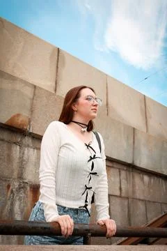 A young model in light-colored jeans walks around the city. Mild spring weather. Stock Photos