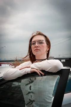 A young model in light-colored jeans walks around the city. Mild spring weather. Stock Photos