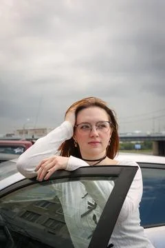 A young model in light-colored jeans walks around the city. Mild spring weather. Stock Photos