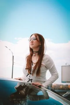 A young model in light-colored jeans walks around the city. Mild spring weather. Stock Photos