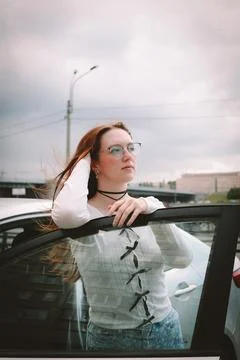 A young model in light-colored jeans walks around the city. Mild spring weather. Stock Photos