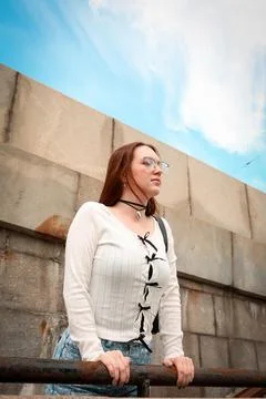 A young model in light-colored jeans walks around the city. Mild spring weather. Stock Photos