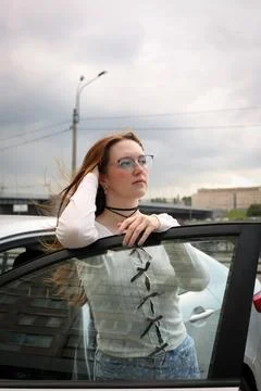 A young model in light-colored jeans walks around the city. Mild spring weather. Stock Photos