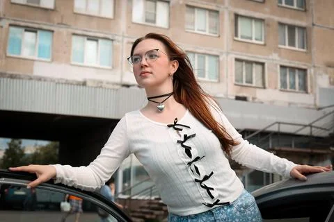 A young model in light-colored jeans walks around the city. Mild spring weather. Stock Photos