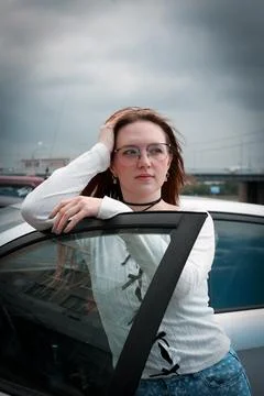 A young model in light-colored jeans walks around the city. Mild spring weather. Stock Photos