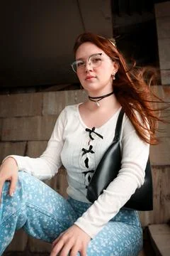 A young model in light-colored jeans walks around the city. Mild spring weather. Stock Photos