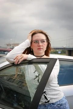 A young model in light-colored jeans walks around the city. Mild spring weather. Stock Photos