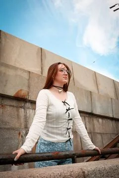 A young model in light-colored jeans walks around the city. Mild spring weather. Stock Photos