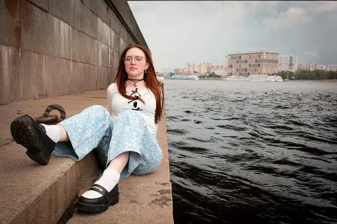 A young model in light-colored jeans walks around the city. Mild spring weather. Stock Photos