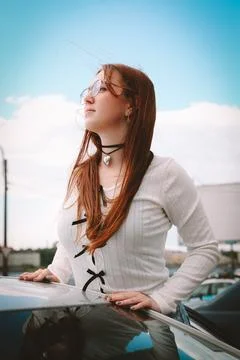 A young model in light-colored jeans walks around the city. Mild spring weather. Stock Photos