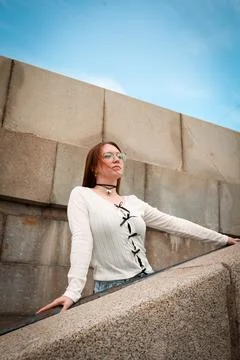 A young model in light-colored jeans walks around the city. Mild spring weather. Stock Photos