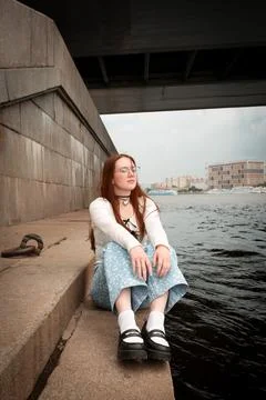 A young model in light-colored jeans walks around the city. Mild spring weather. Stock Photos