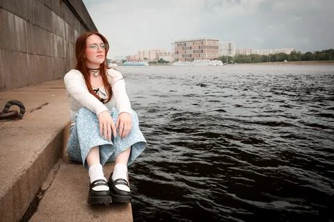 A young model in light-colored jeans walks around the city. Mild spring weather. Stock Photos