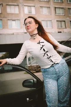 A young model in light-colored jeans walks around the city. Mild spring weather. Stock Photos