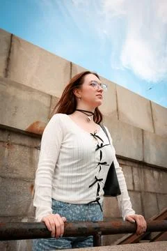 A young model in light-colored jeans walks around the city. Mild spring weather. Stock Photos
