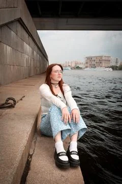 A young model in light-colored jeans walks around the city. Mild spring weather. Stock Photos
