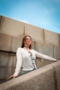 A young model in light-colored jeans walks around the city. Mild spring weather. Stock Photos