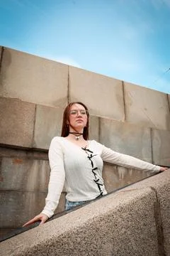 A young model in light-colored jeans walks around the city. Mild spring weather. Stock Photos