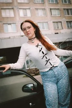 A young model in light-colored jeans walks around the city. Mild spring weather. Stock Photos