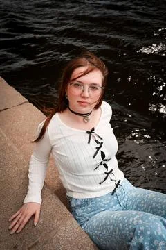 A young model in light-colored jeans walks around the city. Mild spring weather. Stock Photos