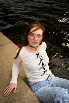 A young model in light-colored jeans walks around the city. Mild spring weather. Stock Photos