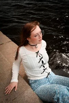 A young model in light-colored jeans walks around the city. Mild spring weather. Stock Photos