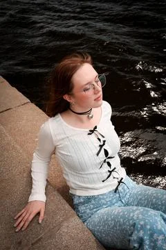 A young model in light-colored jeans walks around the city. Mild spring weather. Stock Photos
