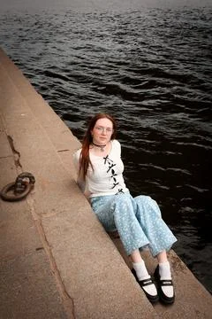 A young model in light-colored jeans walks around the city. Mild spring weather. Stock Photos