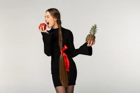 Young model with long braid and red bow wearing black dress Stock Photos