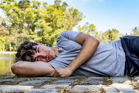 A young model man, lying on the ground while looking at camera Stock Photos