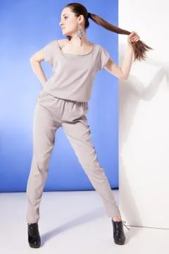 Young model in overall posing while holding long tail Stock Photos