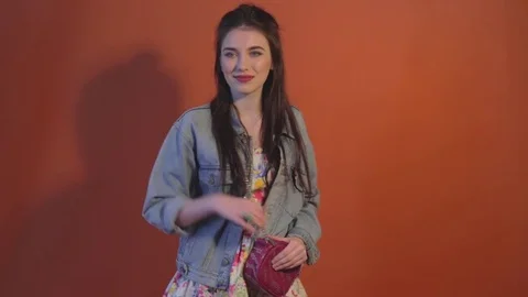 Young model pose dressed in clothes and casts shadow on wall Stock Footage 73416884