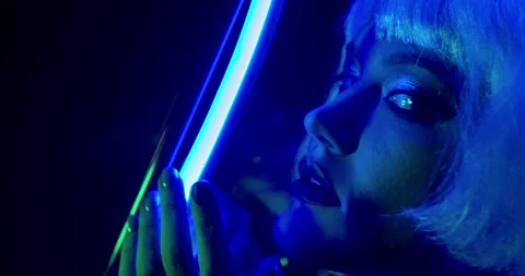 Young model is posing with the blue neon light, sexual moves, 4k Stock Footage 133030240