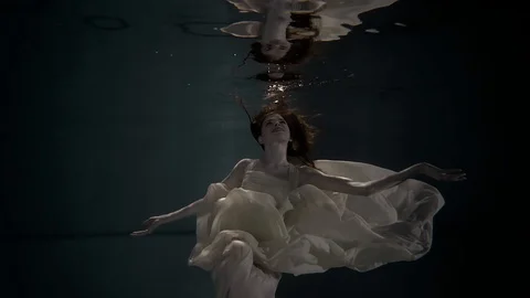 Young model posing in a wedding dress under the water, on top of her reflection Stock Footage 88871015