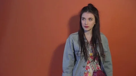 Young model prepare to pose dressed in clothes and casts shadow on wall Stock Footage 73274530