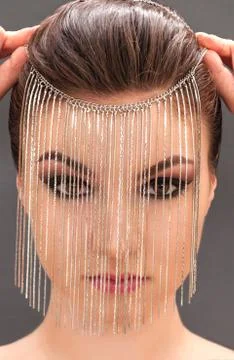 Young model with professional make up closing her face with metal mask Stock Photos