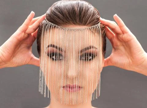 Young model with professional make up closing her face with metal mask Stock Photos