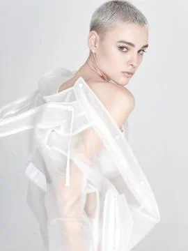 Young model putting on transparent jacket Stock Photos