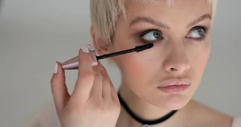 Young model woman is client of professional make up artist applying mascara  Stock Footage 90929448