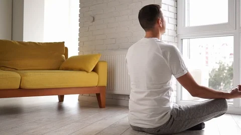Young modern caucasian man practice yoga lotus pose sitting on the floor in Stock-Footage 124308085
